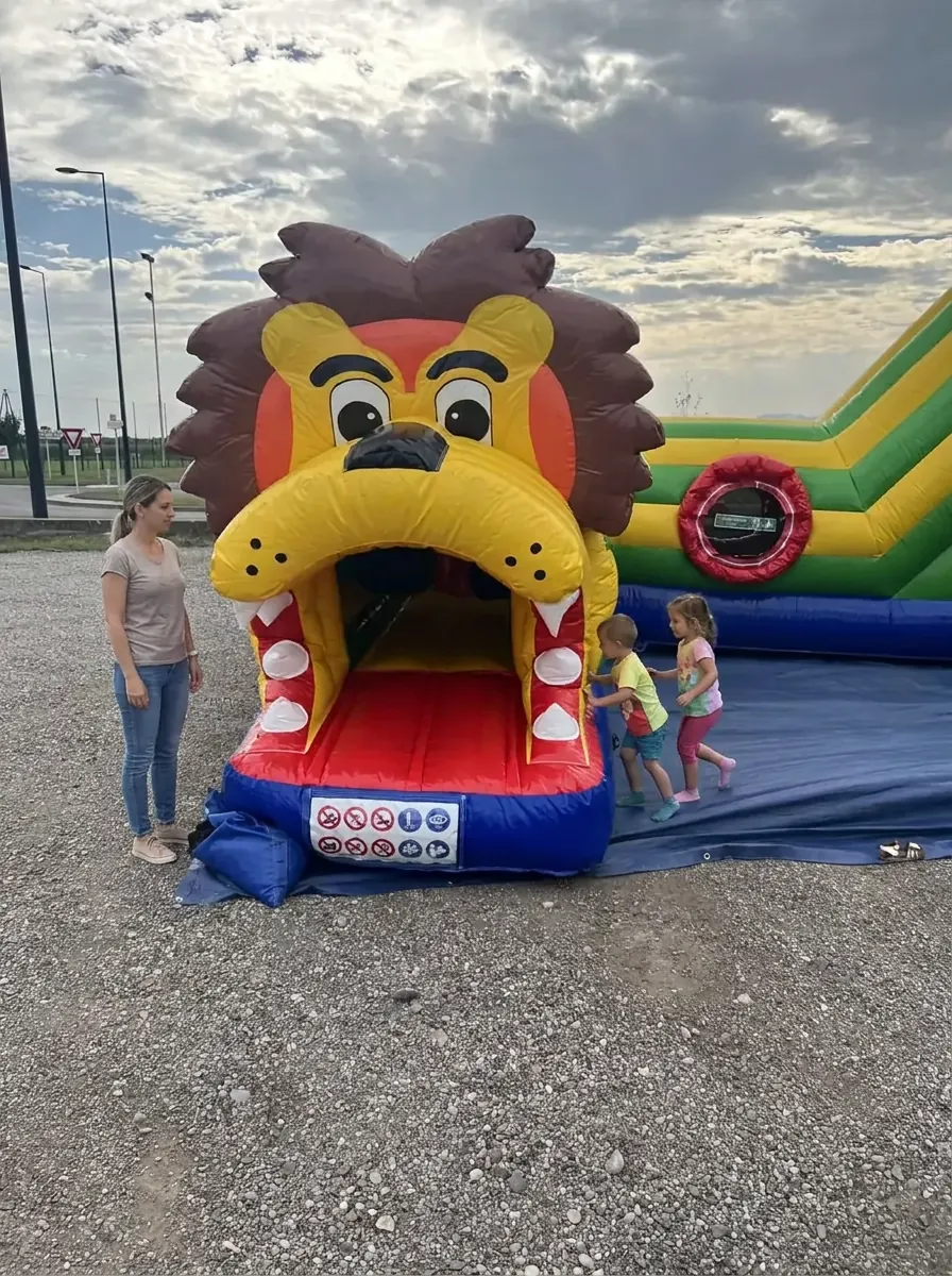 Tunnel gonflable Lion de 3,2 m de haut avec deux enfants et un adulte à côté pour visualiser la taille réelle